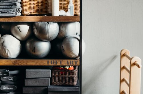 Neatly arranged gym and yoga equipment on wooden shelves, perfect for fitness studios.